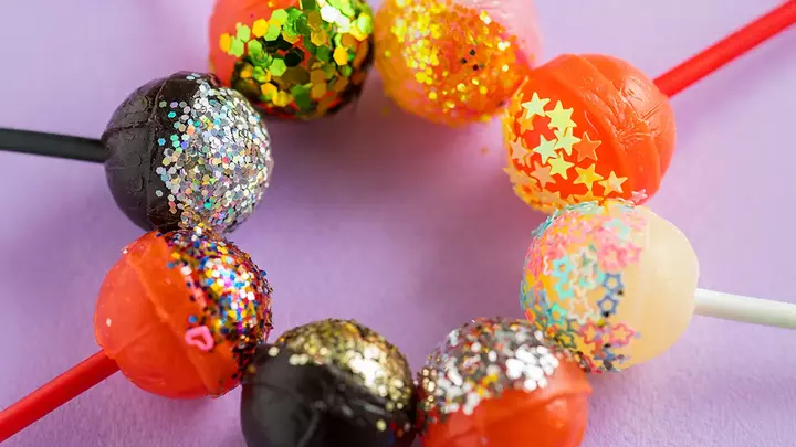 Sugary foods that age your face Colorful lollypops in a circle with glitter on them